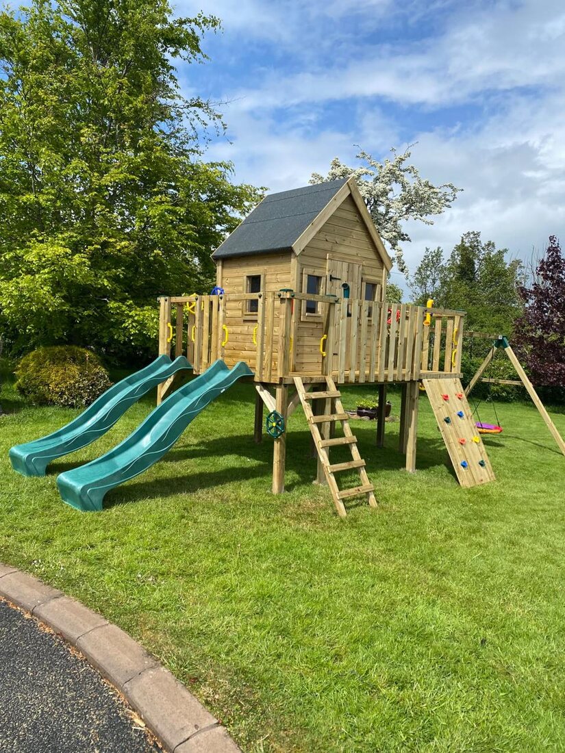 Custom play house with two slides and swings